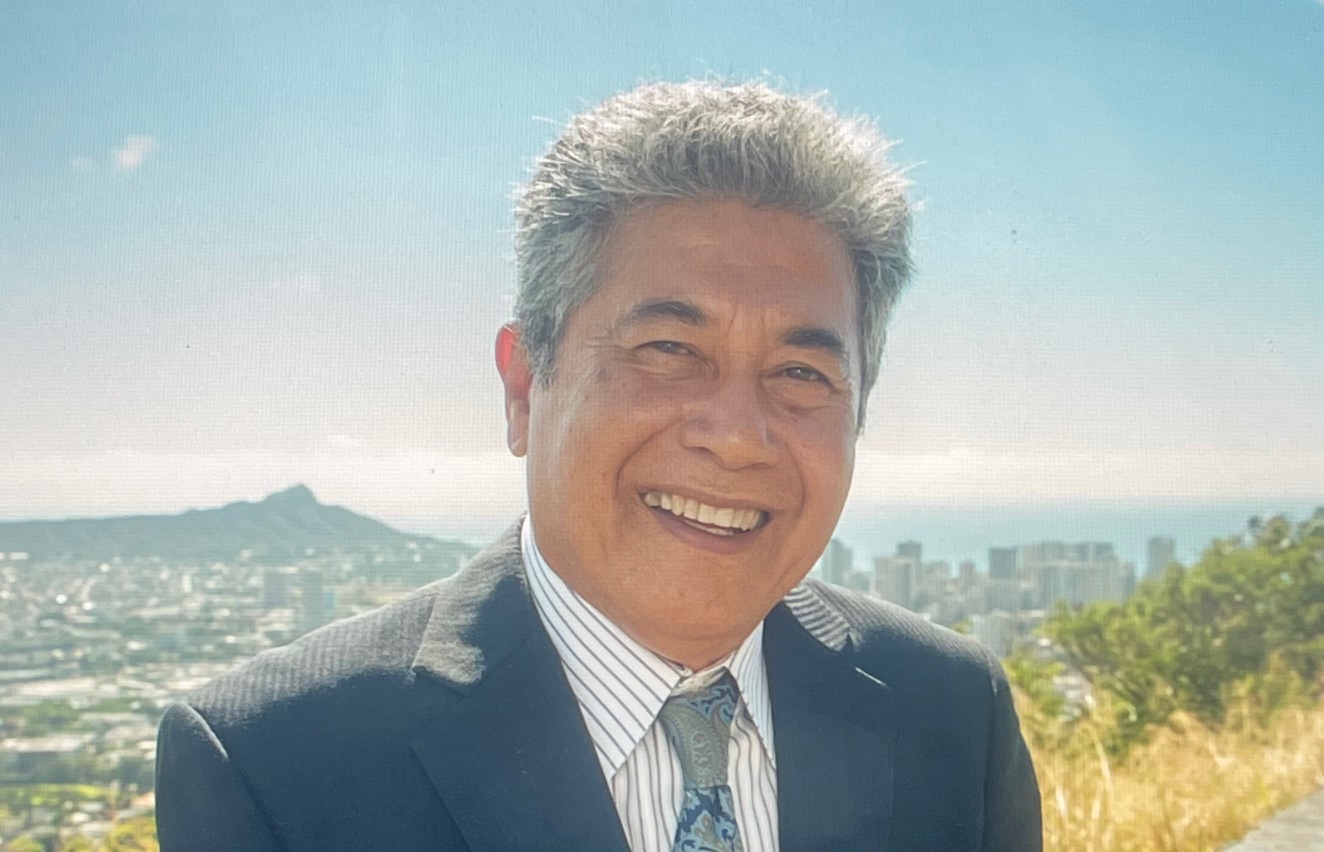 Larry Kiyohiro, Esq., smiling in a suit with a cityscape background, representing Tax Relief Heroes' expertise in tax resolution services.