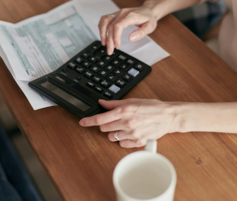 Person using a calculator to assess tax documents and financial information, reflecting the theme of taxpayer assistance and IRS resolution services.